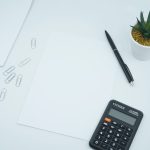 black calculator beside black pen on white printer paper